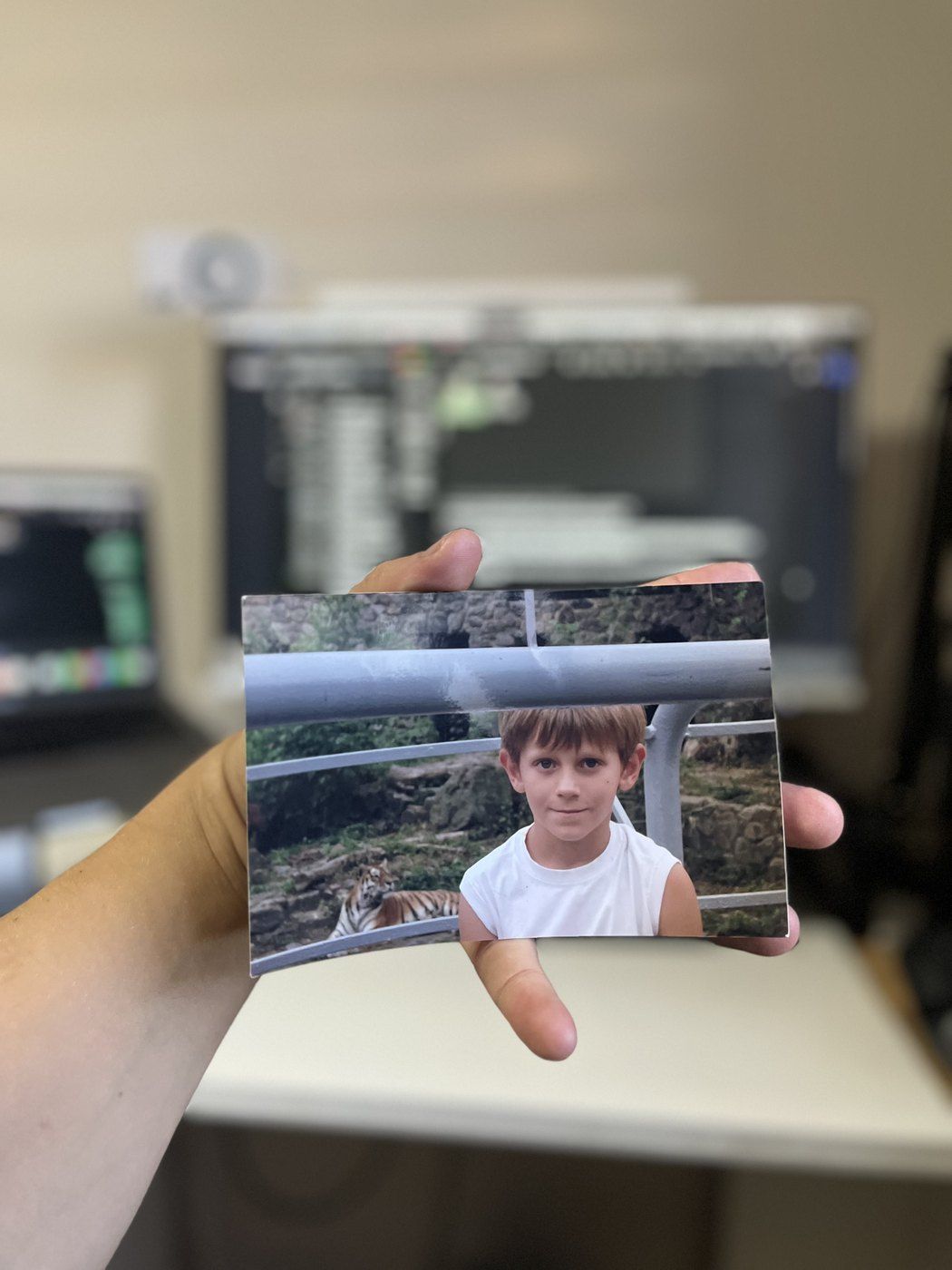 La mano de Taras sostiene hoy una copia impresa de una foto de su infancia: un niño delante de un tigre
