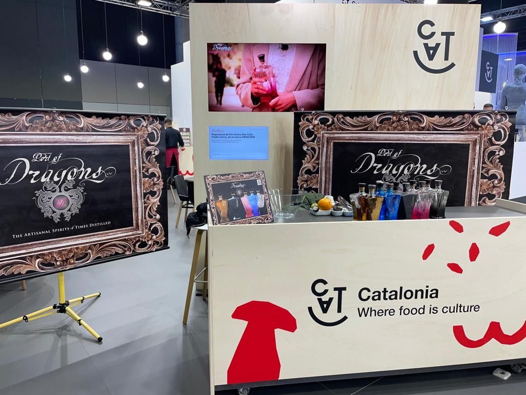 Stand de Port of Dragons en el Fòrum Gastronòmic de Girona, con botellas expuestas y la marca Catalonia al fondo