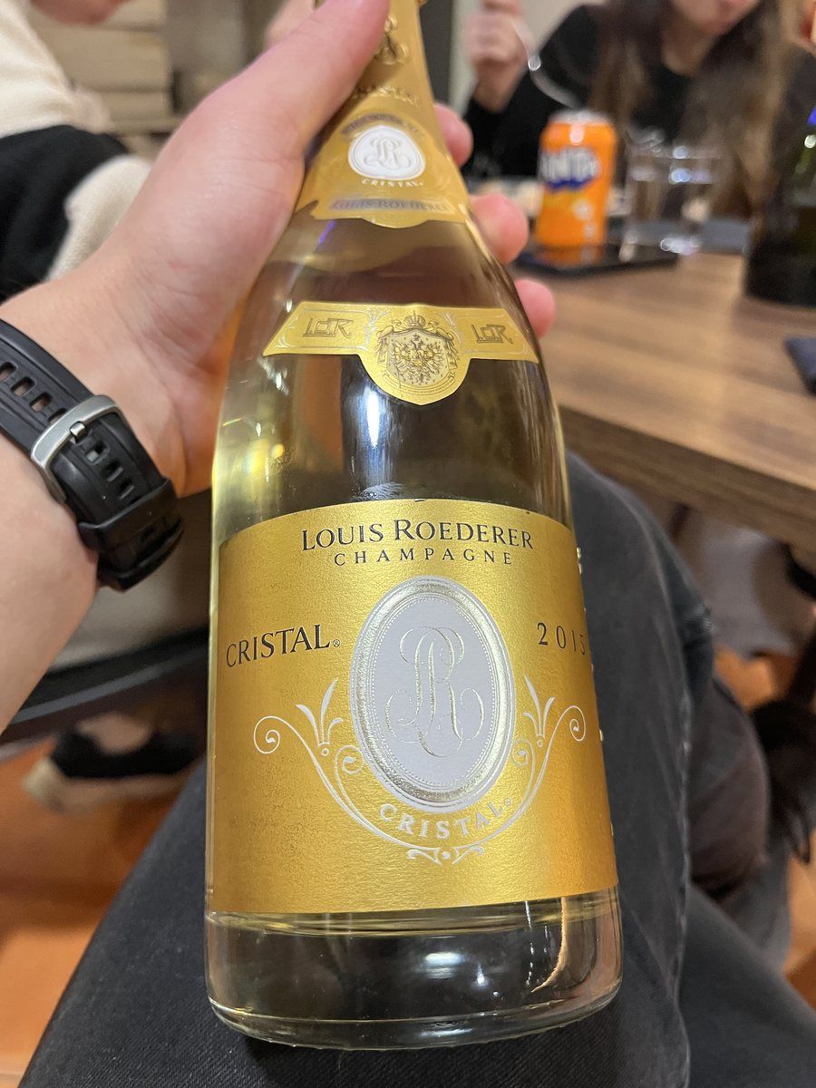 Una botella de champán Louis Roederer Cristal en la mano